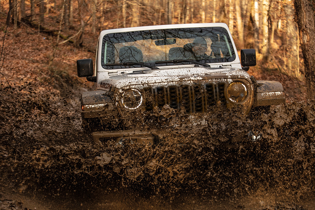 Front view of Jeep Wrangler 2024 crossing a mud puddle