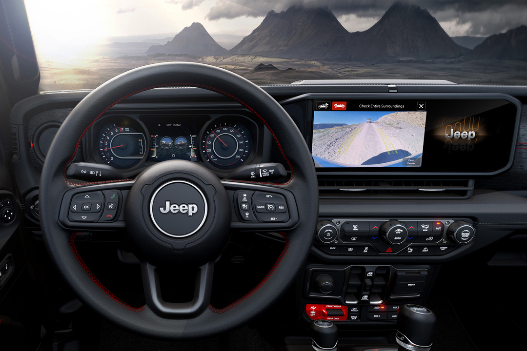 Vue intérieur du Jeep Wrangler 2024 et de son tableau de bord avec vue de montagne